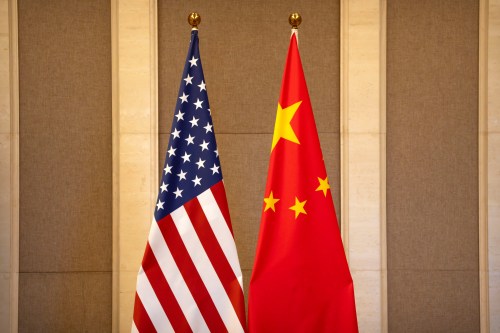A United States flag stands next to a Chinese flag.