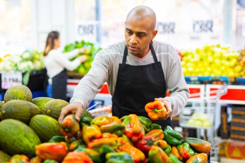 A grocery store worker arranges food