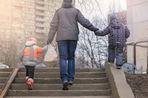 Father walking with two children.