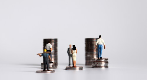 Workers look at coins representing changes in wages