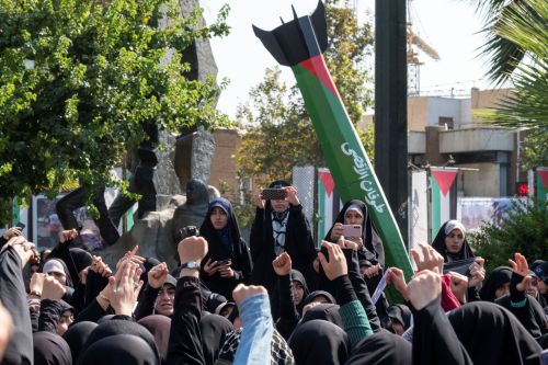 Veiled women shout anti-Israel slogans while standing under an anti-Israel urban artwork constructed and implemented by the municipality of Tehran, symbolizing Iran's support for the Palestinian Al-Aqsa storm missile attack on Israel, during an anti-Israel rally at the Palestine square in downtown Tehran, October 13, 2023.