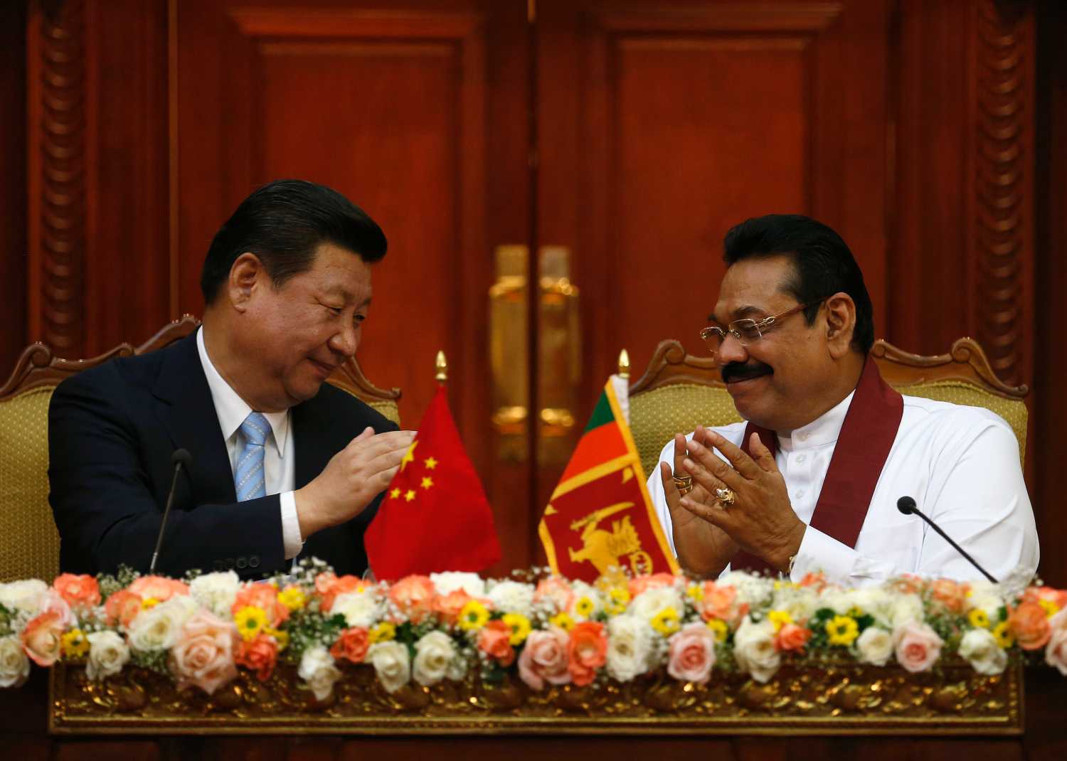 Chinese President Xi Jinping (L) and Sri Lanka's President Mahinda Rajapaksa applaud each other during their bilateral meeting at the Presidential Secretariat in Colombo September 16, 2014. REUTERS/Dinuka Liyanawatte (SRI LANKA - Tags: POLITICS)