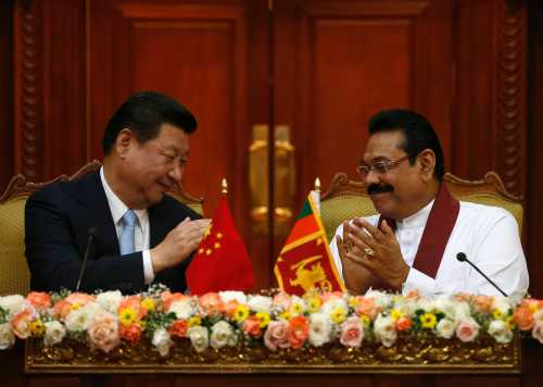 Chinese President Xi Jinping (L) and Sri Lanka's President Mahinda Rajapaksa applaud each other during their bilateral meeting at the Presidential Secretariat in Colombo September 16, 2014. REUTERS/Dinuka Liyanawatte (SRI LANKA - Tags: POLITICS)