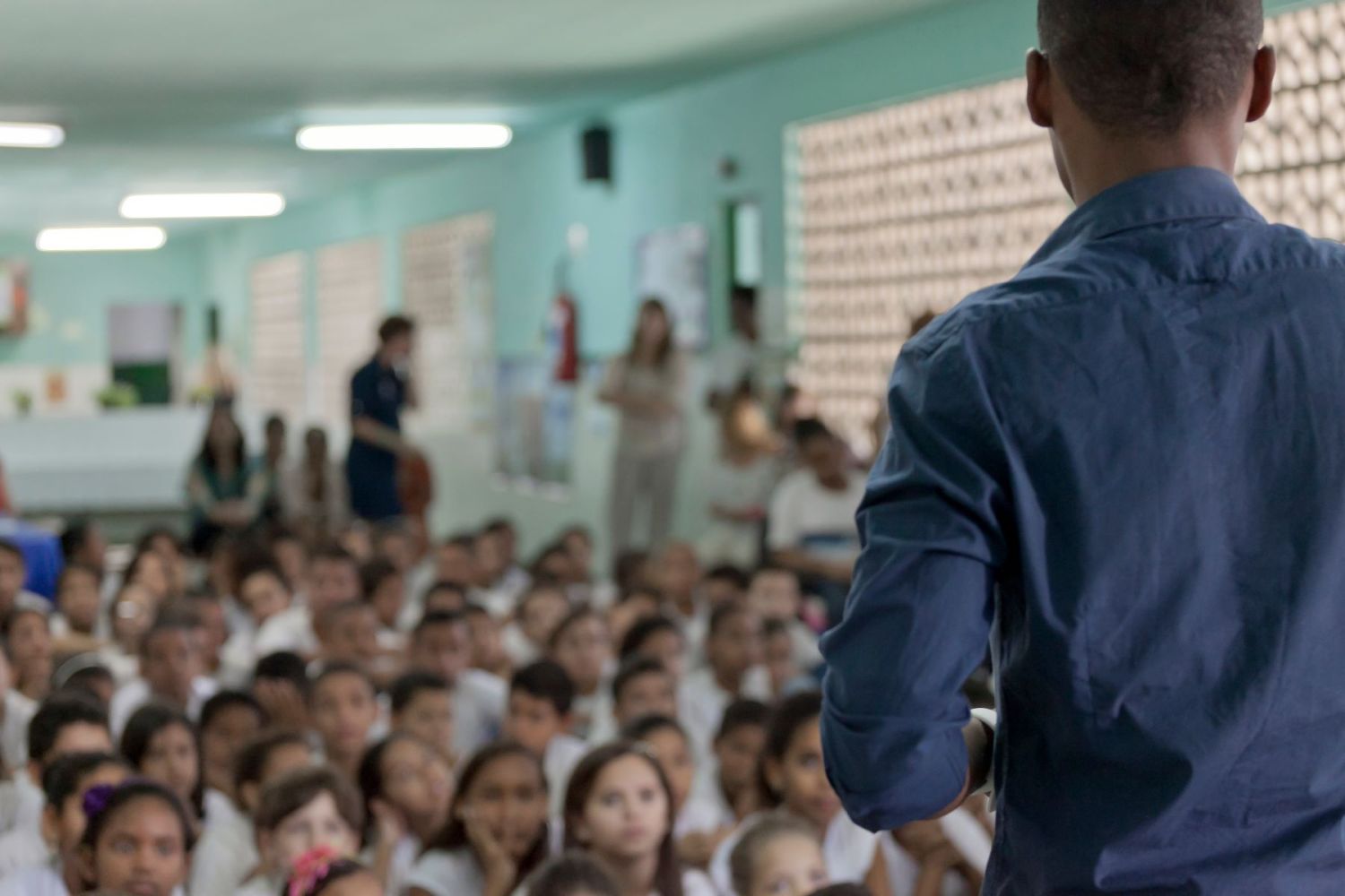 Male teacher standing in front of a classroom full of young students in Brazil