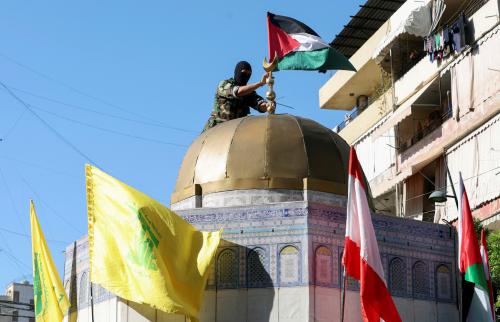 A Hezbollah member puts a Palestinian flag atop of a replica of the Dome of the Rock as people gather to commemorate the annual Hezbollah Martyrs' Day and to express solidarity with the Palestinians in Gaza amid the ongoing conflict between Israel and Hamas, in Sidon, Lebanon, November 10, 2023.
