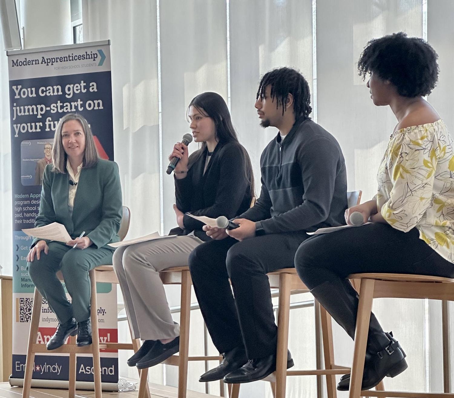 three young apprentices sit on a panel moderated by Annelies Goger