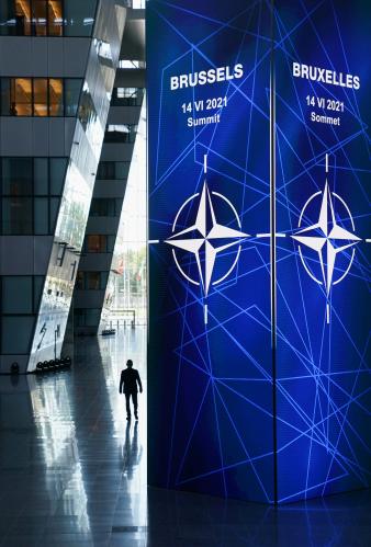 A person walks near a sign during the NATO summit in Brussels, Belgium June 14, 2021