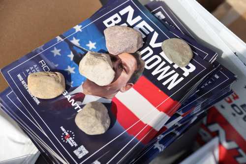 Rocks hold down a pile of literature promoting Florida Governor Ron DeSantis, from his "Never Back Down" political action committee, outside the venue where he kicked his campaign for the 2024 Republican U.S. presidential nomination with an evening campaign rally in West Des Moines, Iowa, U.S. May 30, 2023. Credit: REUTERS/Scott Morgan