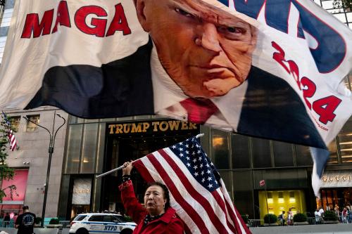 A supporter of former U.S. President Donald Trump holds up a U.S. national flag at Trump Tower in New York City, U.S., October 1, 2023.