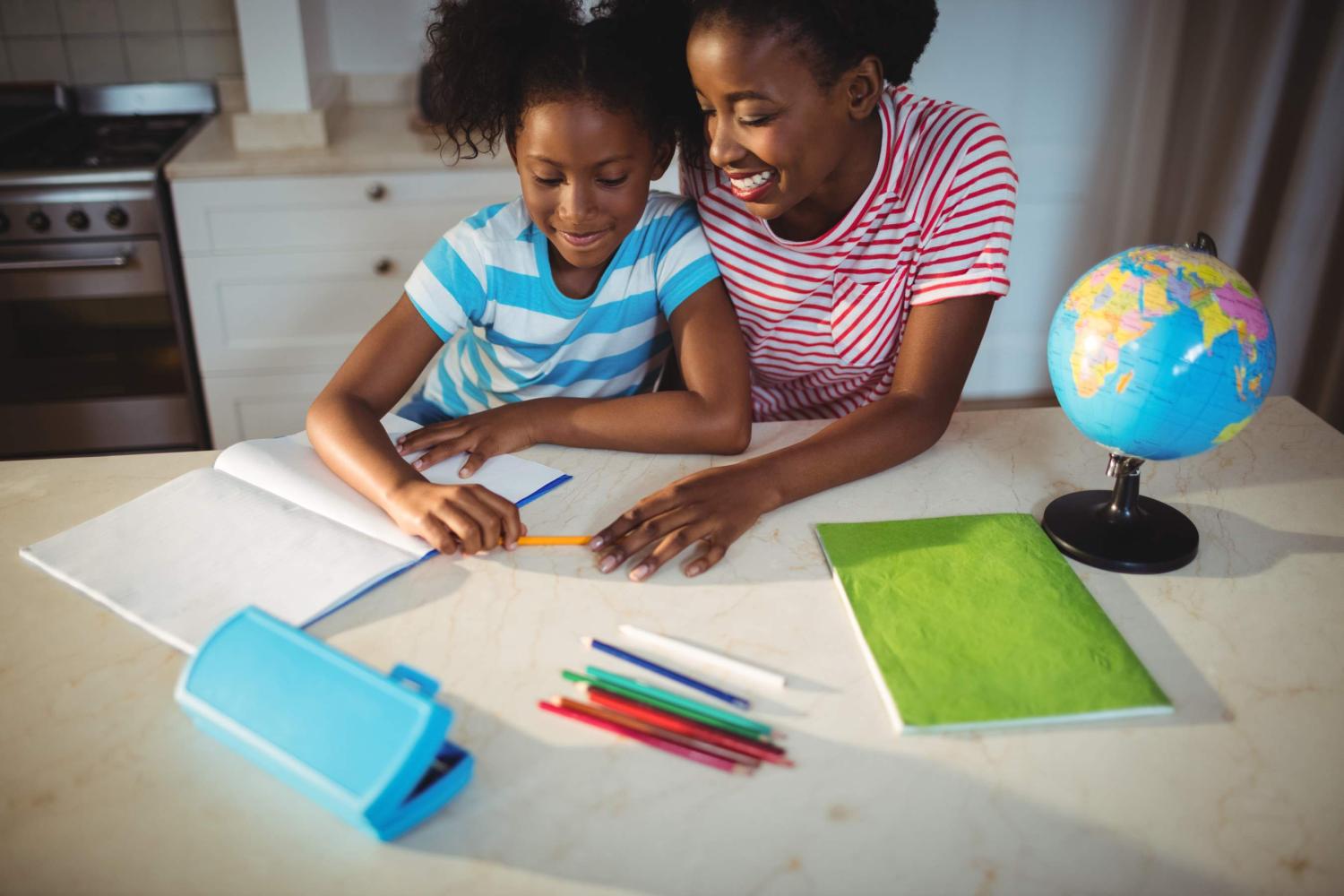 A mother helps her child with homework (Photo credit: WBMUL / Shutterstock)
