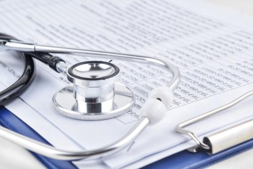 Stethoscope sitting atop medical bills