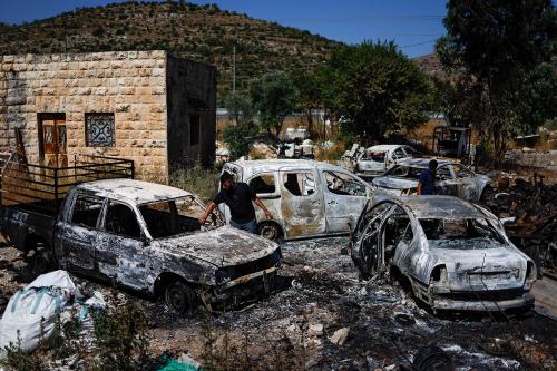 Palestinians check burned vehicles after Israeli settlers attack near Ramallah in the Israeli-occupied West Bank, June 21, 2023.