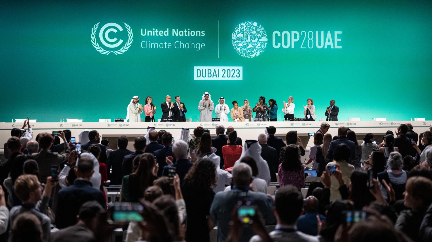 Sultan Ahmed Al-Jaber, President of COP28, (C) and other participants applaud at the conference during the UN Climate Change Conference (COP28)