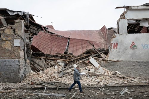 A local resident walks near the sports arena of Lokomotyv Kyiv children's football academy, which was hit by a missile strike in Kyiv, Ukraine.