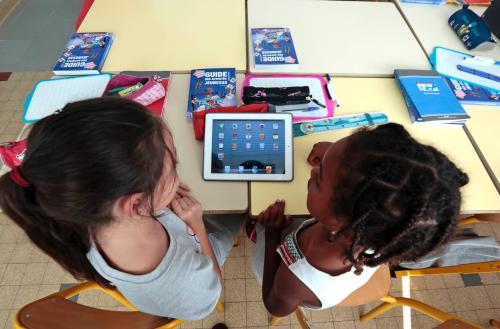 Elementary school children share an electronic tablet on the first day of class in the new school year, September 3, 2013. REUTERS/Eric Gaillard