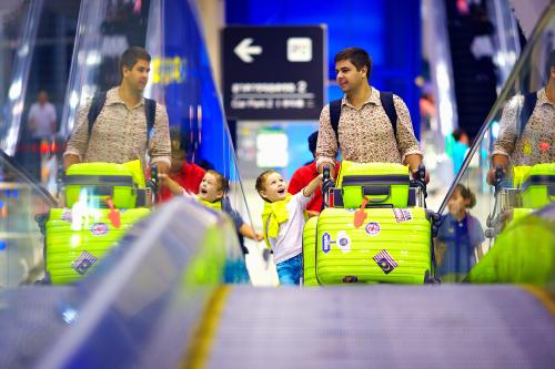 happy family with baggage on conveyor in airport, ready to travel