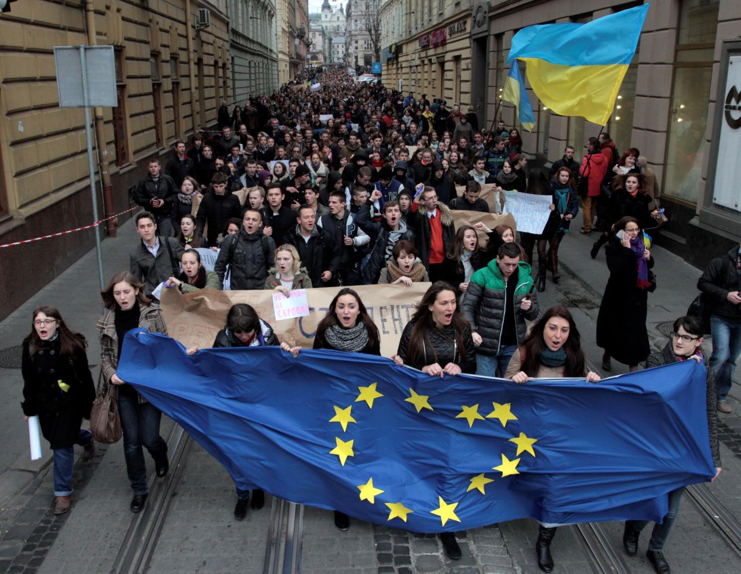 Students hold Ukrainian and European Union flags during a rally to support euro integration in the central area of the western Ukrainian city of Lviv, November 22, 2013.