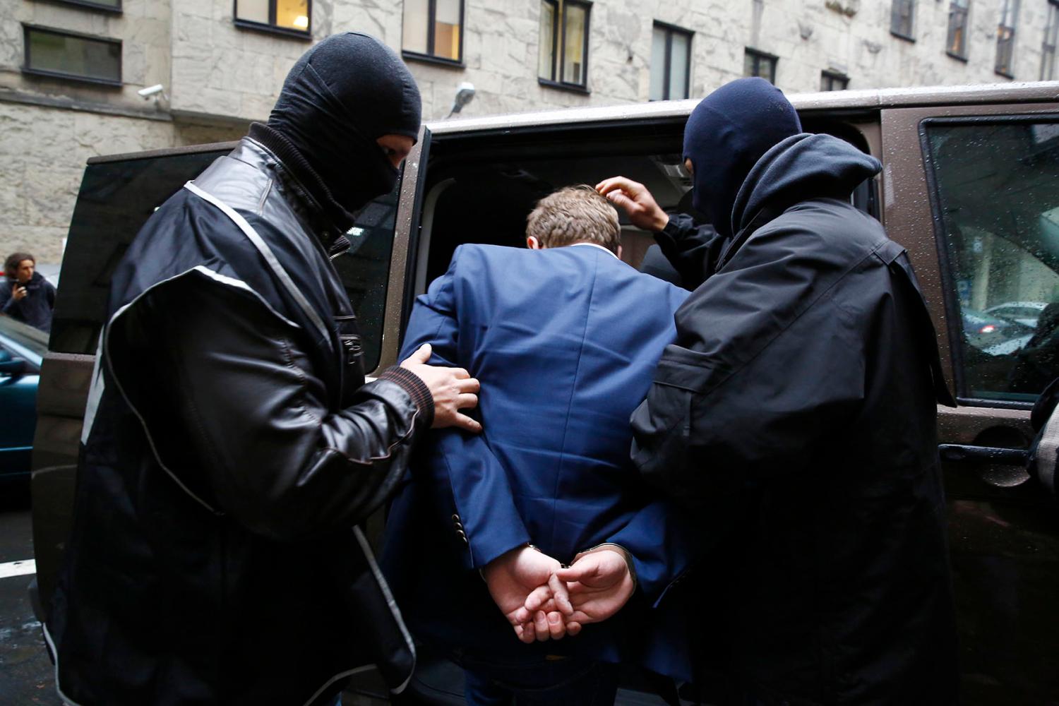The Internal Security Agency (ABW) officers escort a man arrested on suspicion of spying in front of the district court in Warsaw October 17, 2014.