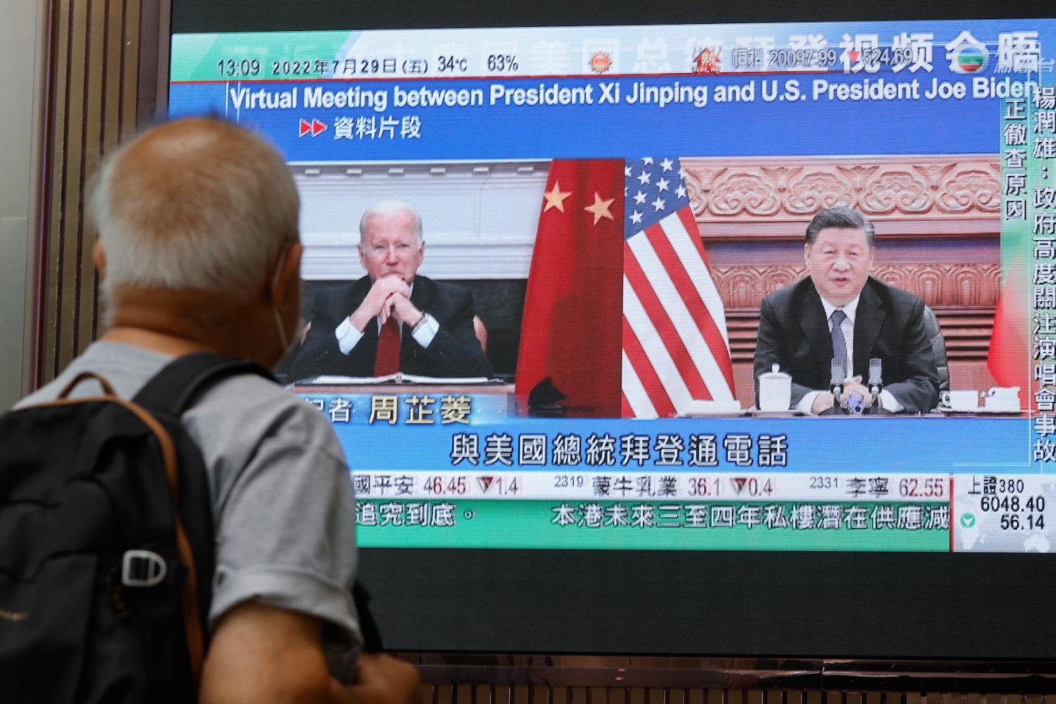 A screen displays images of Chinese President Xi Jinping and U.S. President Joe Biden, while broadcasting news about their recent call at a shopping mall in Hong Kong, China, July 29, 2022.