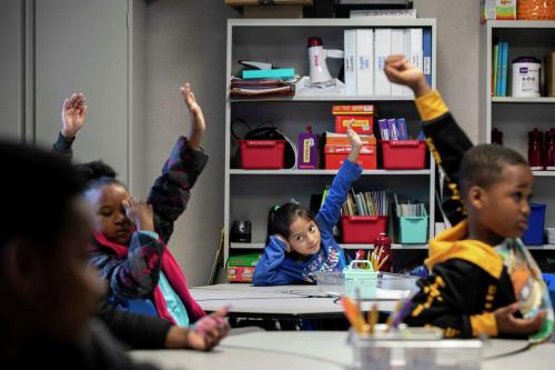 First graders raise their hands to ask questions while learning about the water cycle at Essence Preparatory Public School in San Antonio in March.