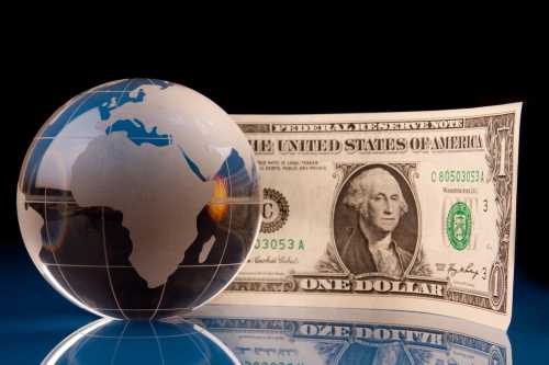 Globe focused on Africa and American money on glossy blue background