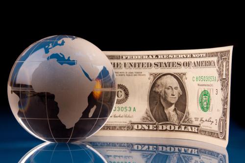 Globe focused on Africa and American money on glossy blue background