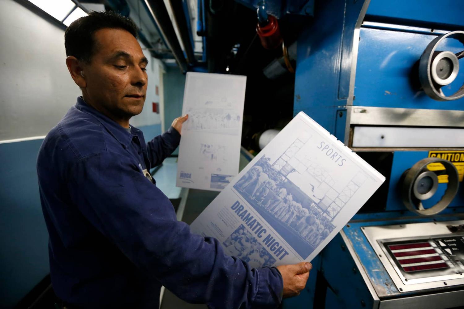 Printer Jose Lomeli holds newspaper printing plates for the first copies of the inaugural Los Angeles Register newspaper in Santa Ana, California.