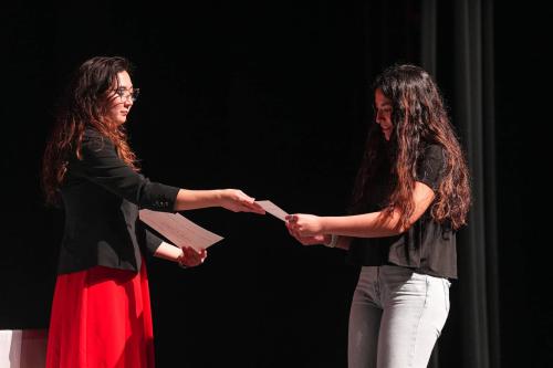 First-year National Hispanic Institute student Alyssa Enriquez recieves a certificate from volunteer Natalia Chapa Mills at an induction ceremony at William B. Travis High School on Sunday, May 7, 2023 in Austin. Students recieved certificates that affirm they will be part of the team representing the Austin area in the upcoming Great Debate competition.