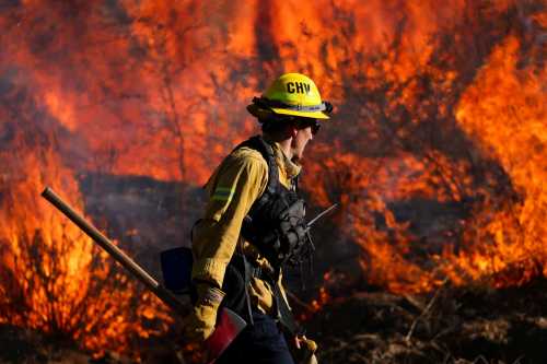 A firefighter works to extinguish the Highland Fire, a wind driven wildfire near Aguanga, California, U.S., October 31, 2023.