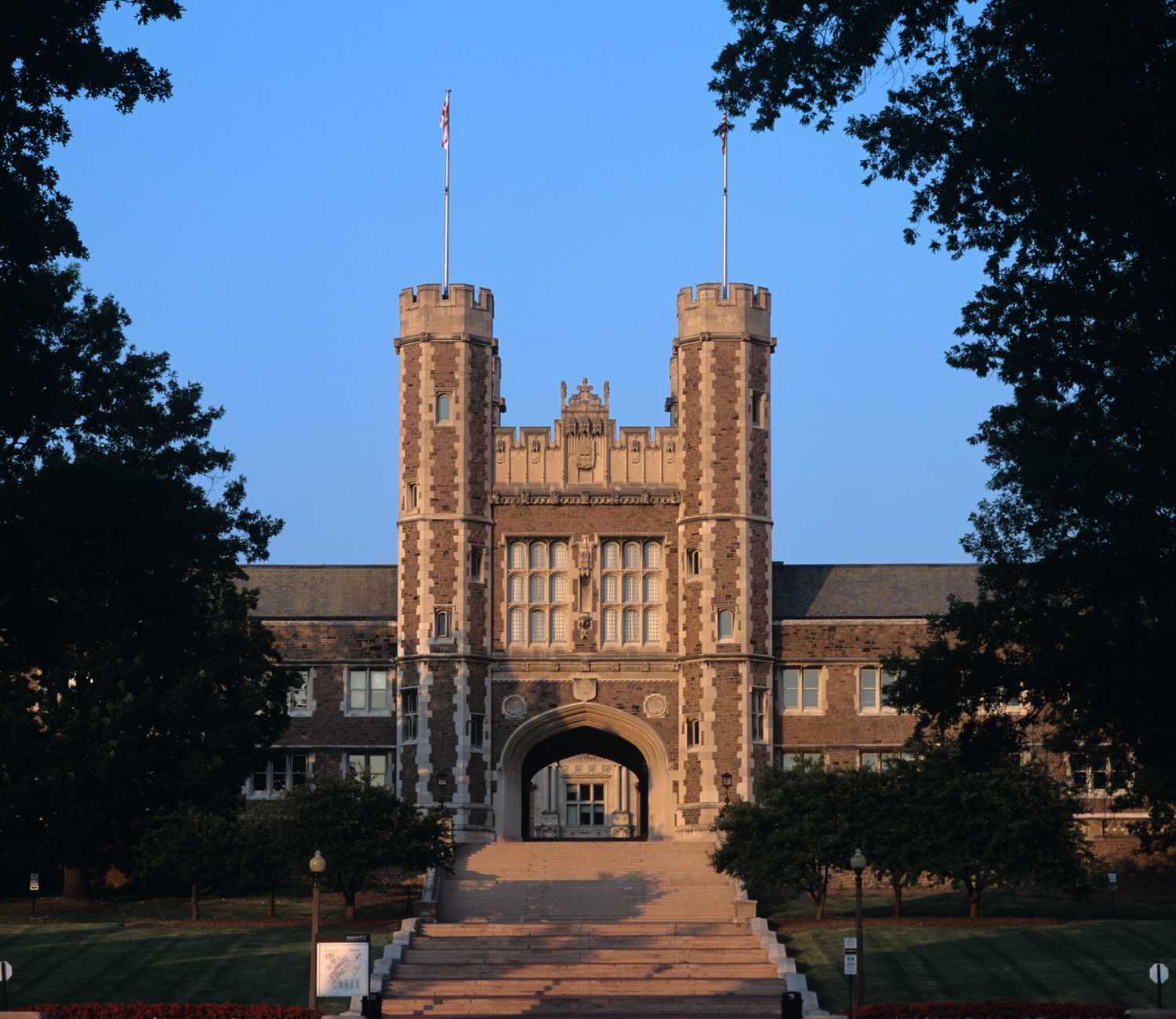 Gothic building with two towers, surrounded by trees