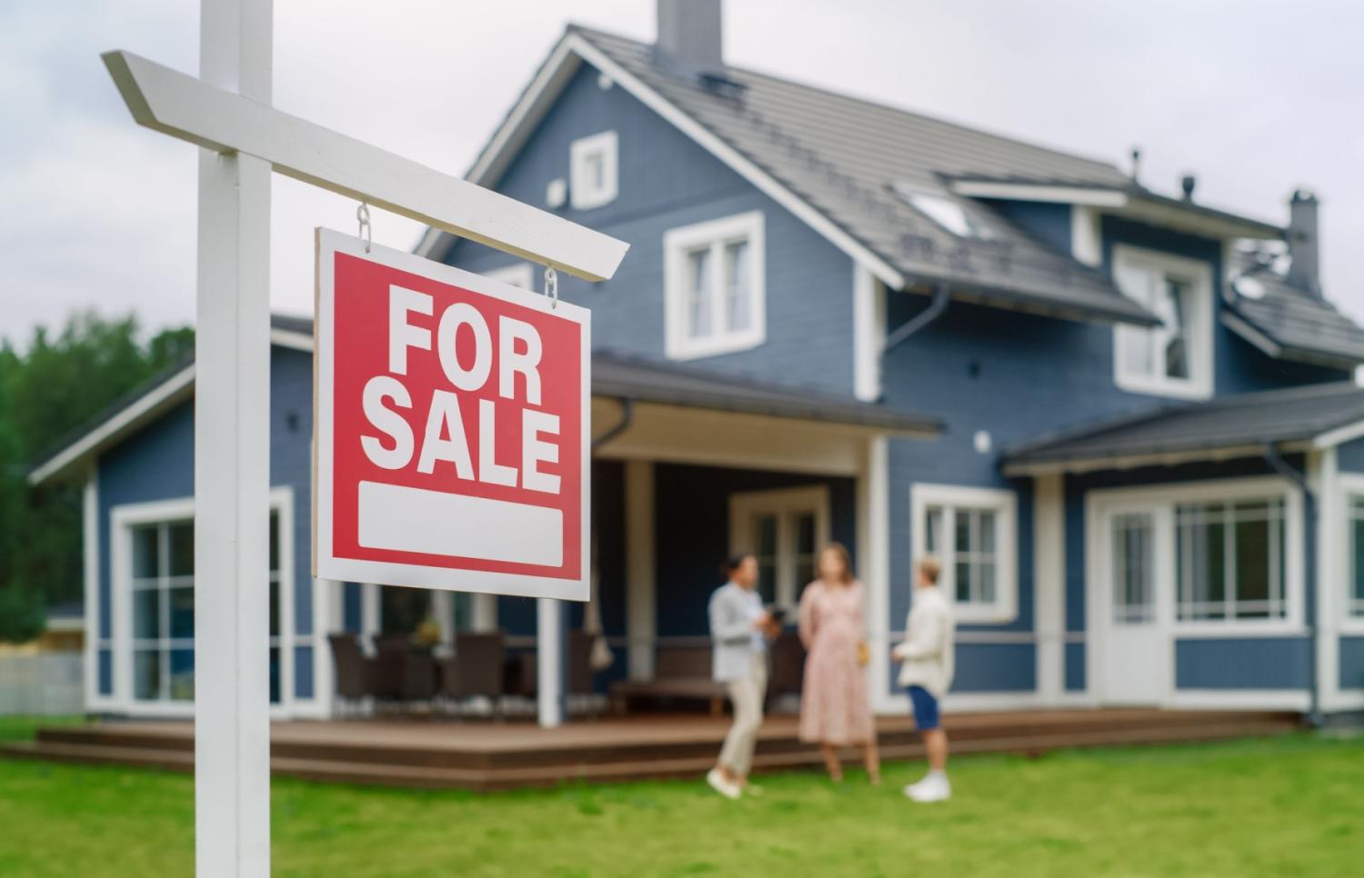 House with for sale sign in front of it.