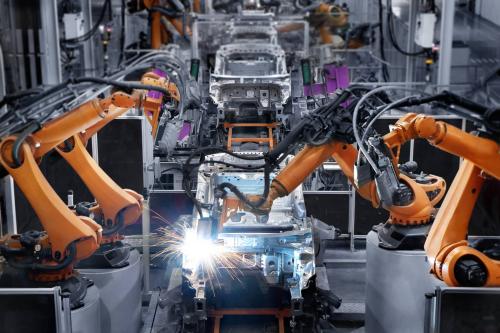 Robots weld cars together on an assembly line