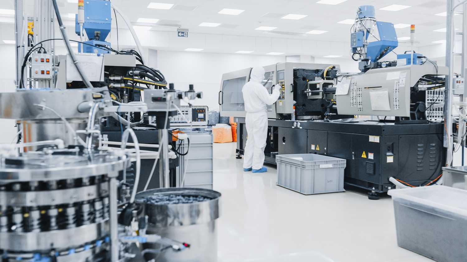 On a Factory Scientist in Sterile Protective Clothing Work on a Modern Industrial 3D Printing Machinery. Biotechnological and Semiconductor Manufacturing Process Shot from Inside.
