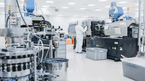 On a Factory Scientist in Sterile Protective Clothing Work on a Modern Industrial 3D Printing Machinery. Biotechnological and Semiconductor Manufacturing Process Shot from Inside.