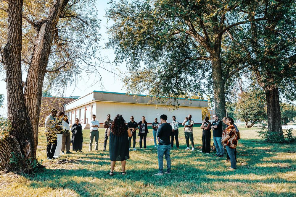 Diverse group standing in a circle outside in the Greenwood District of Tulsa, Oklahoma
