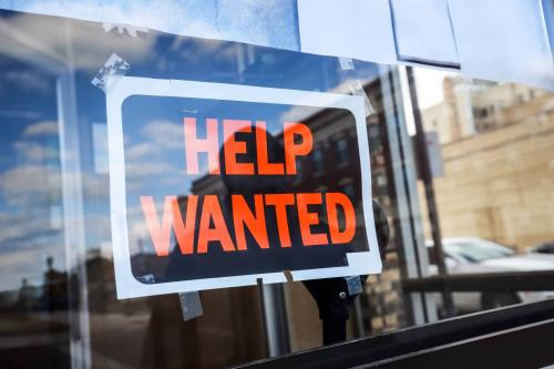 A help wanted sign displayed in a store window
