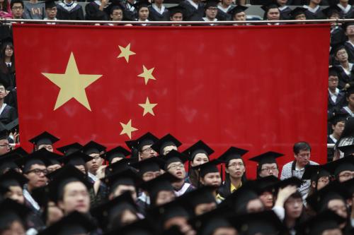 Graduates set next to the Chinese flag during a graduation ceremony at Fudan University in Shanghai, June 28, 2013.
