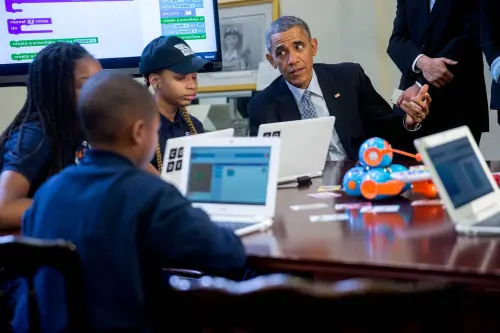 Former U.S. President Barack Obama talks to middle-school students who are participating in an "Hour of Code" event in the Eisenhower Executive Office Building next to the White House in Washington, D.C., U.S., on Monday, Dec. 8, 2014. The event is in honor of Computer Science Education Week.