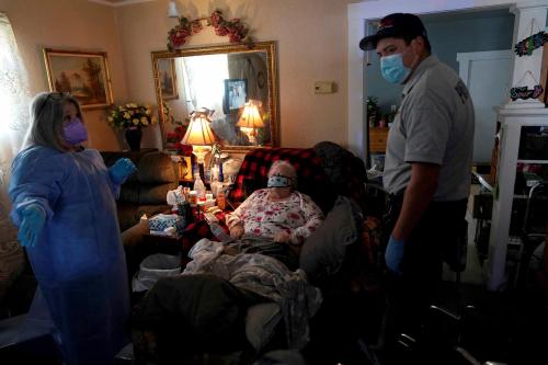 A REACT EMS paramedic talks with a home health nurse in the home of an 82 year old woman suffering from possible coronavirus disease (COVID-19) symptoms after she was exposed to a COVID-19 positive family member in Shawnee, Oklahoma, U.S. January 12, 2022.