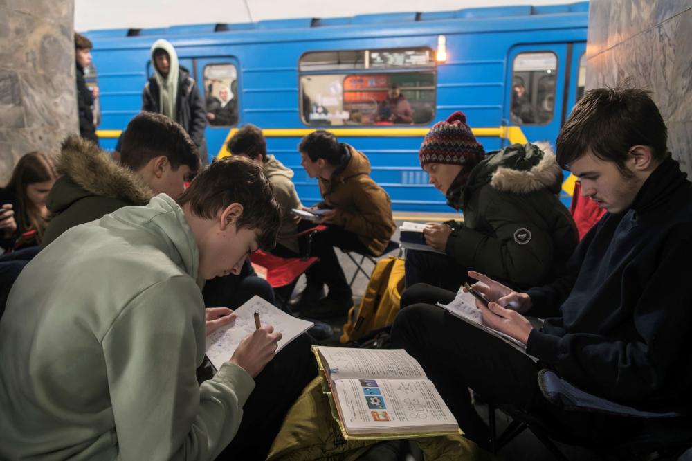 Schoolchildren are completing a school assignment in a metro station being used as a bomb shelter during a long air alert in Kyiv, Ukraine, on February 9, 2024.