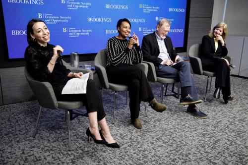 Moderator and three panelists, all seated, participating in a discussion