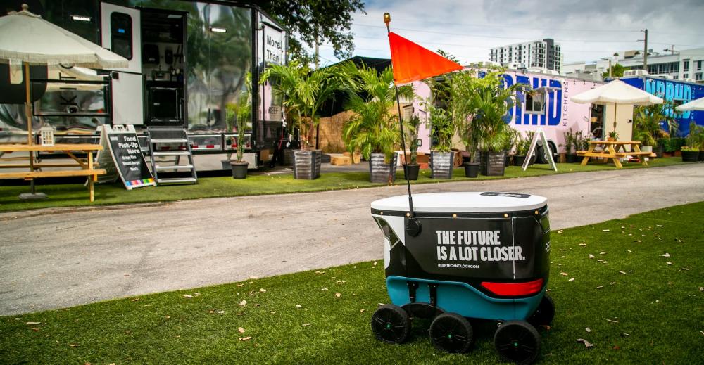 A delivery robot sits in Section 9, located in the Brickell area of Miami, among restaurants operated by REEF, on Tuesday, March 30, 2021. REEF, the largest operator of parking lots and neighborhood hubs in North America, officially launched its first robot delivery service in Miami's downtown.