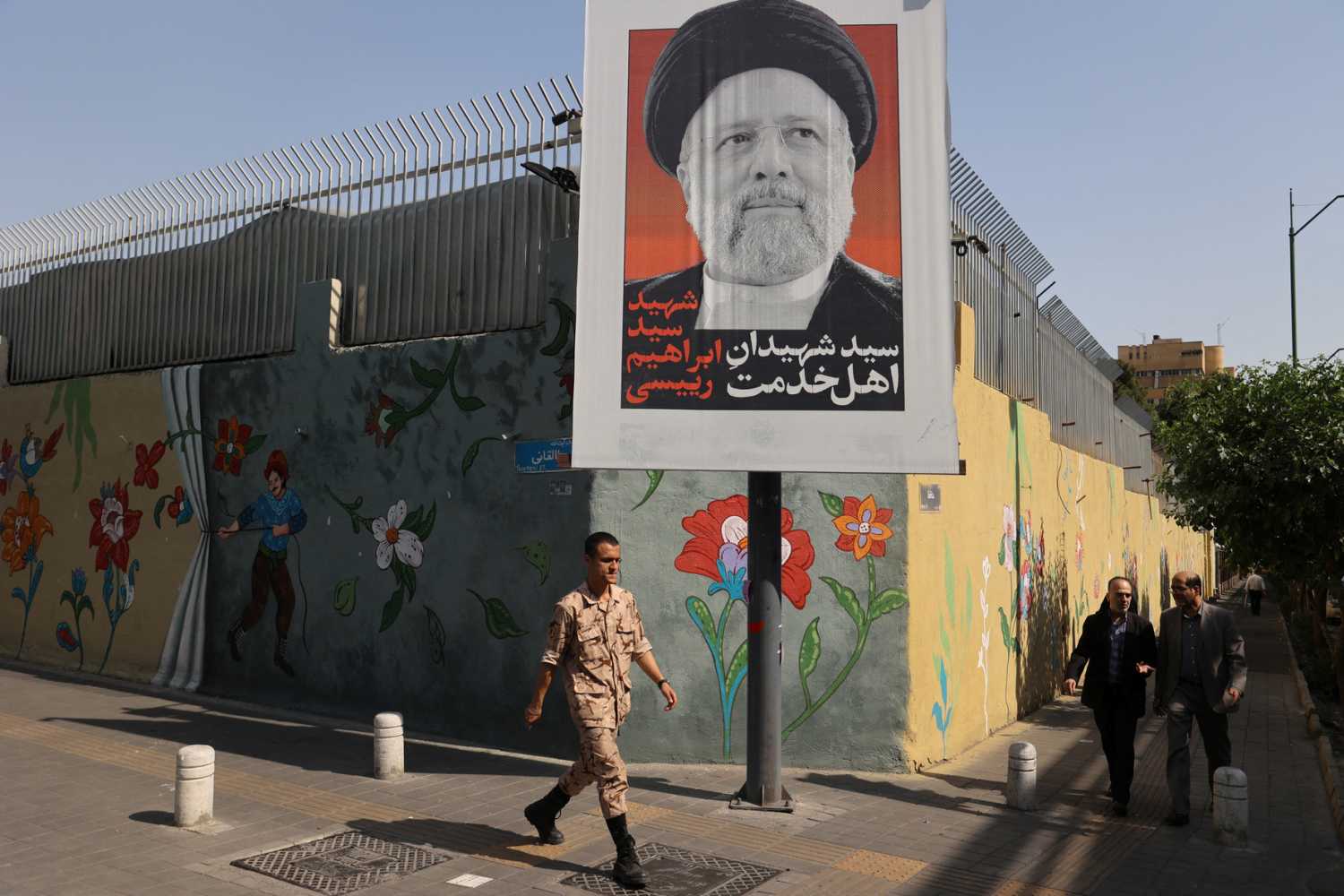 A person walks past a banner with a picture of Iran's late president, Ebrahim Raisi, on a street in Tehran, Iran, May 20, 2024.