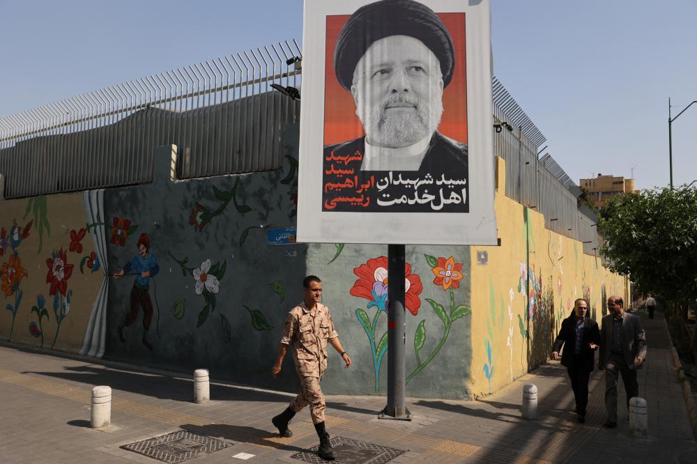 A person walks past a banner with a picture of Iran's late president, Ebrahim Raisi, on a street in Tehran, Iran, May 20, 2024.