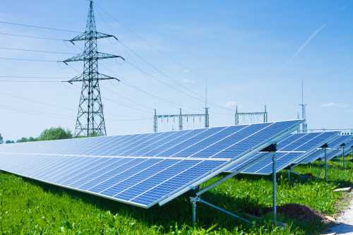 Solar panels and power lines representing the permitting for clean energy infrstructure