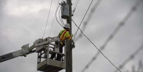 Lineman hanging fiber cables in Macon County, Alabama