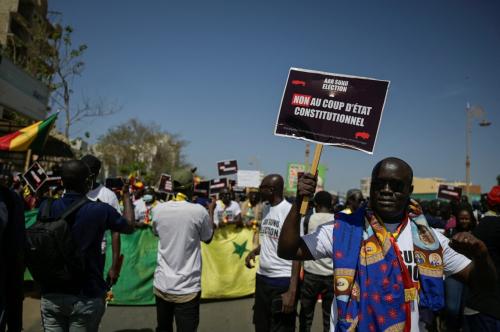 A Senegalese holds a sign that reads "No to constitutional coup d'etat" during a march to protest the postponement of the February 25 presidential election. Dakar, Senegal February 17, 2024.