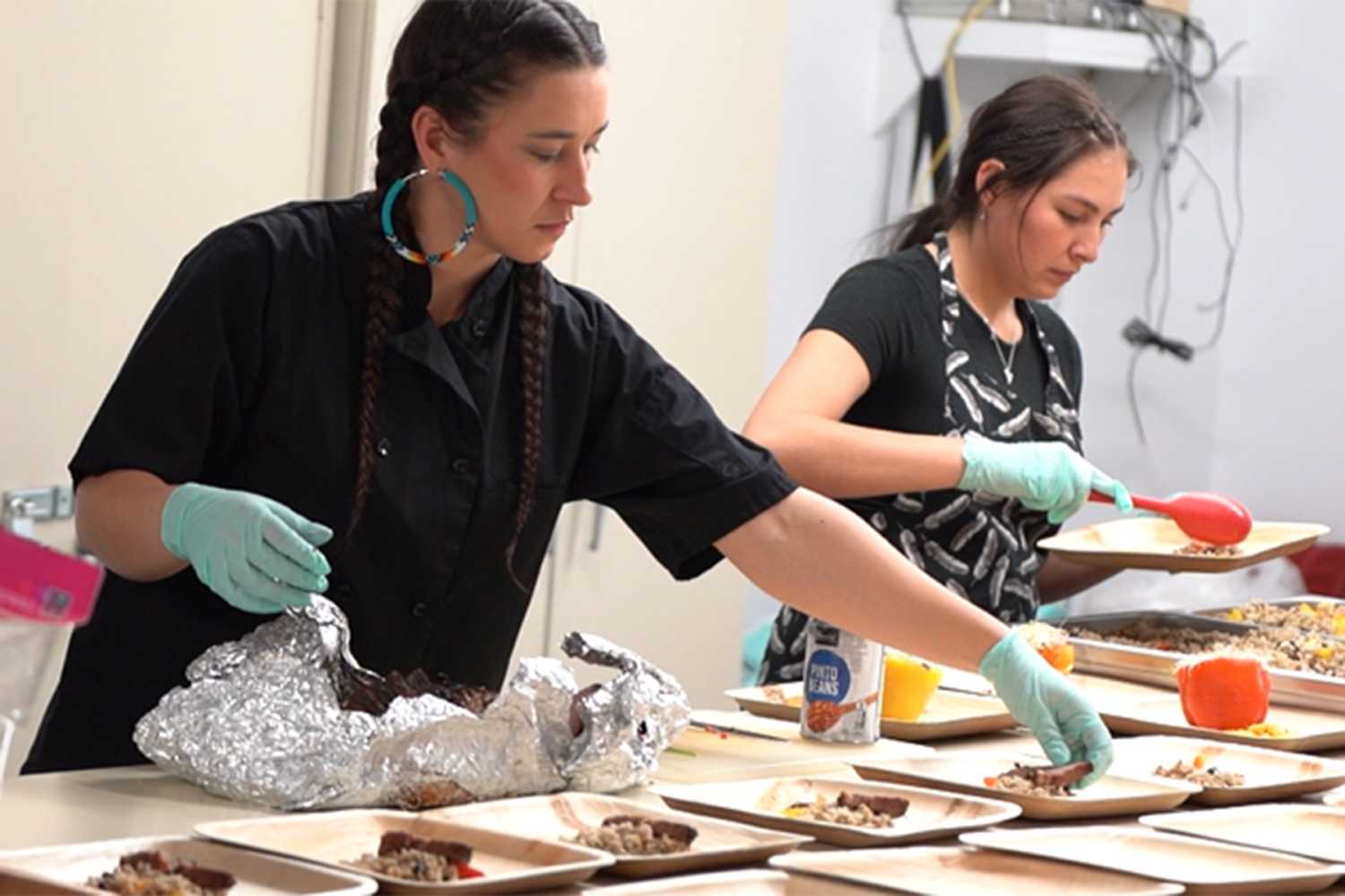 Marah Gladstone, a Blackfeet Chef focused on Indigenous Food Sovereignty, plates the Coalition meals with the help of her Indigenous servers.