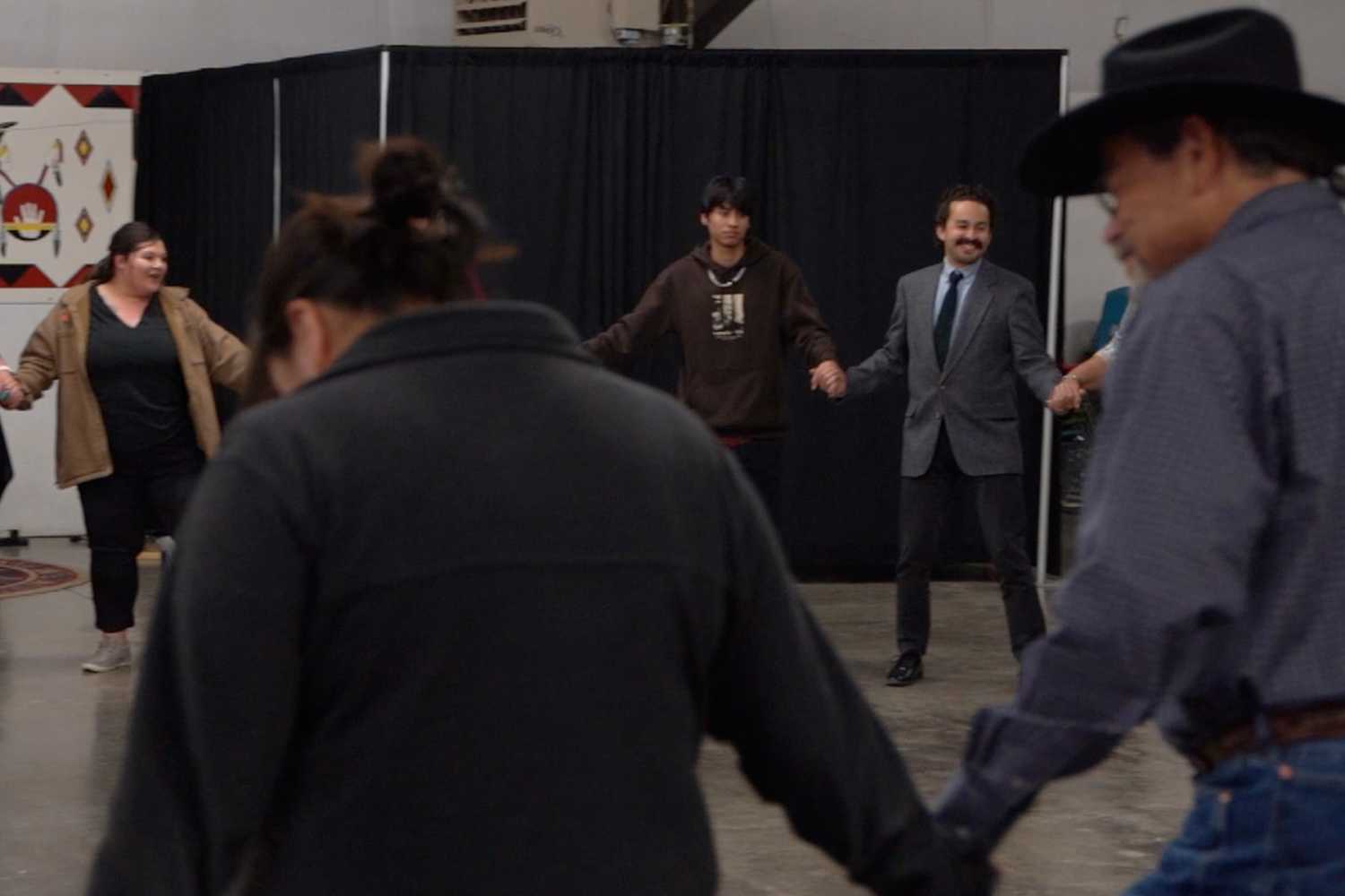 Attendees of the Mountain | Plains Indigenous Finance Gathering ending the day with a round dance, an Indigenous social dance popular at powwows, showcasing unified action to fortify the Indigenous Finance Industry.