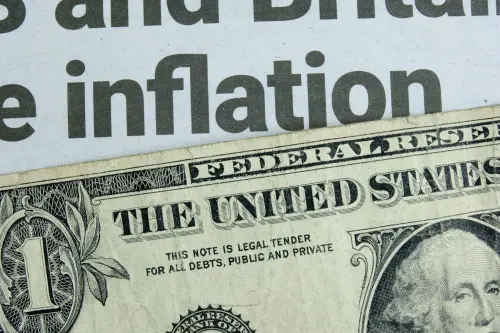 $1 bill laid over a news headline reading "inflation"